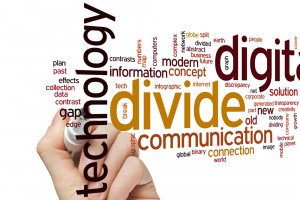 A hand holding a marker is drawing a word cloud on a white background. Prominent words include "technology," "divide," "communication," and "digital," with various related terms such as "government," "information," "internet," "gap," and "connection" dispersed throughout.